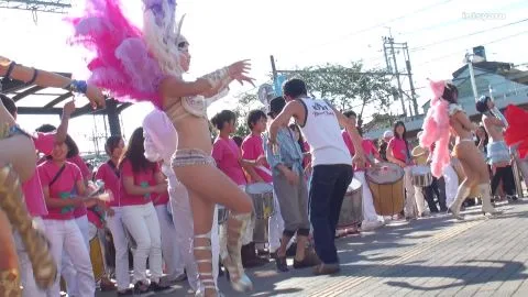 Asian Performers Dancing on Street with Feathered Headdress