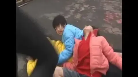 Asian Performers Engaging in Intimate Wrestling and Embracing