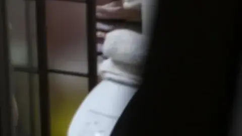 Asian Teen in Dimly Lit Bathroom