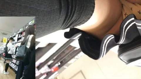 Asian teen in skirt poses in DVD store