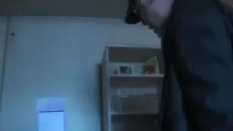 Asian Couple Embraces in Dimly Lit Room