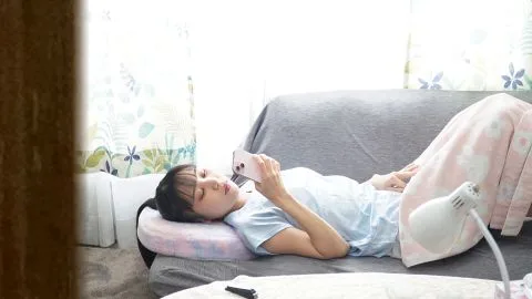 Asian teen relaxes on couch in lingerie