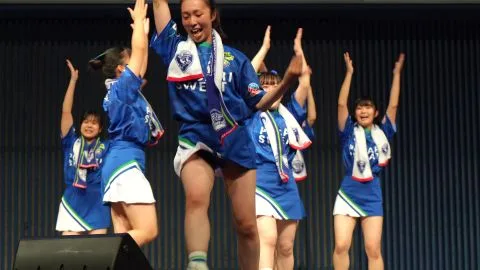 Asian Performers Dancing on Stage with Blue Scarves