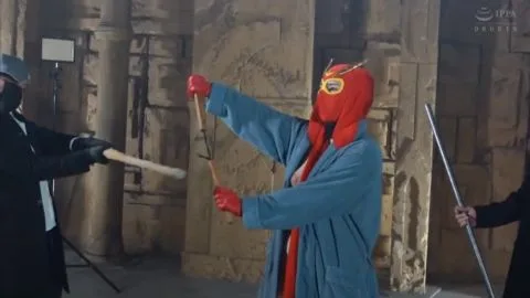 Asian Man in Red Mask and Robe in Stone Hallway
