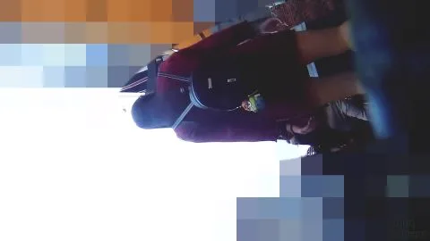 Asian Girl in Red Shirt Reaches for Something in Store