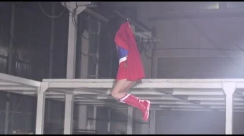 Asian Woman in Red Outfit Hanging in Industrial Setting