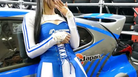 Brunette posing near car and tires