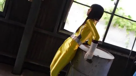 Asian Woman in Yellow Bodysuit in Industrial Setting