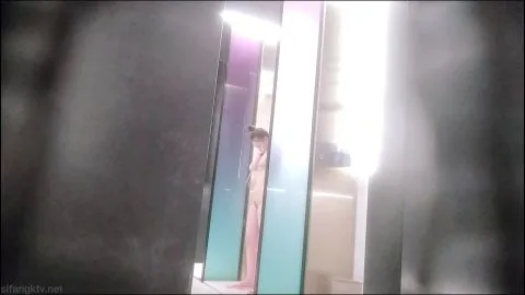 Asian Brunette Combing Hair in Bright Bathroom