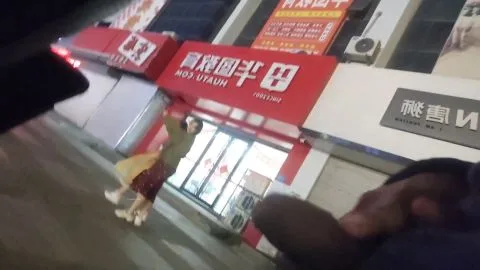 Asian girl in red skirt walks down street