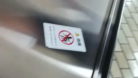 Asian Woman in Business Suit on Escalator