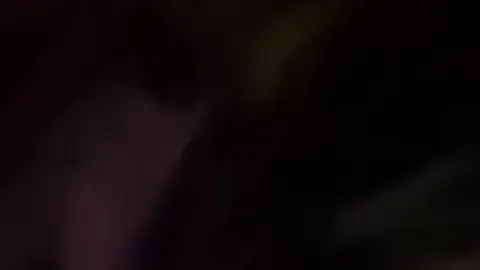 Asian teen with mask lies on purple bed sheets