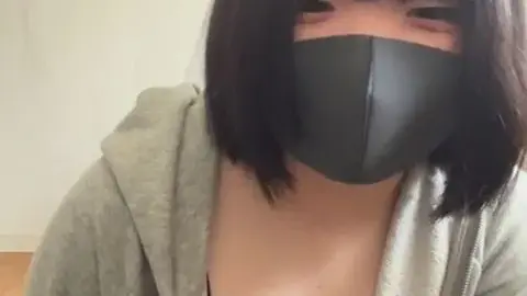 Asian teen with dark brown hair and face mask poses
